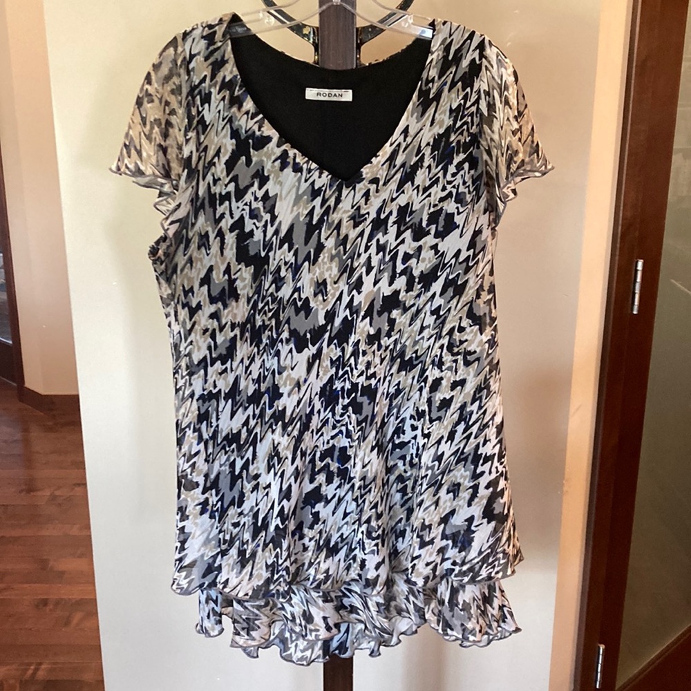 Tunic style sleeveless top, ruffle detail at bottom